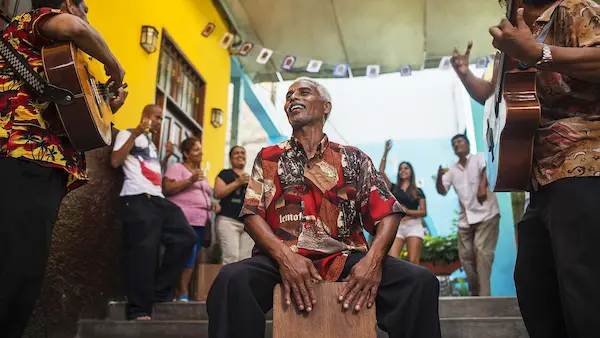 Una persona tocando el cajón mostrando el origen de la canción criolla