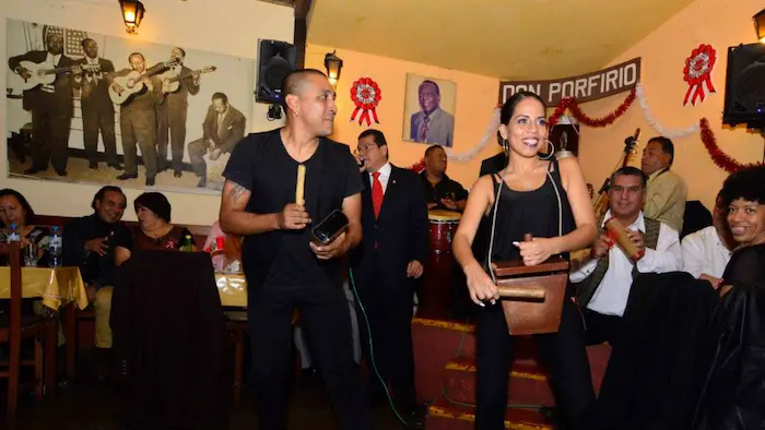 Personas en un bar celebrando el día de la canción criolla 