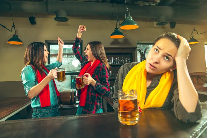 mujer un poco ebria con dolor de cabeza sentada dentro de un bar