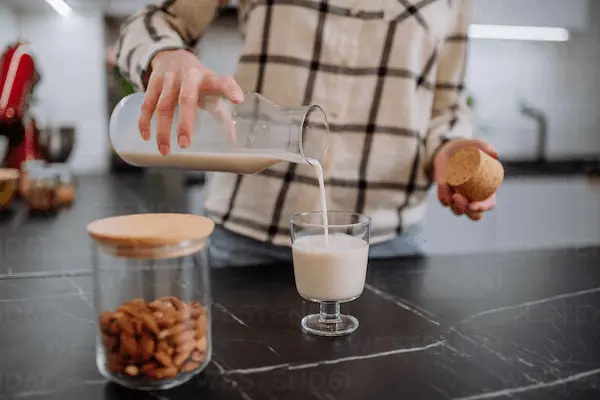Persona disfrutando un vaso de malta con leche, apreciando aroma, espuma y textura