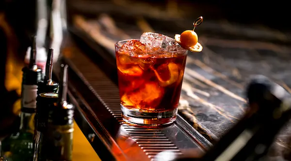 tragos con whisky para jóvenes en mesa con hielo frutas y vasos modernos