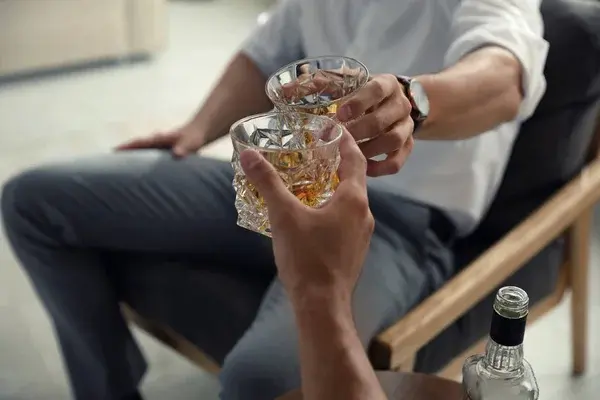 jóvenes disfrutando tragos con whisky en reunión social moderna