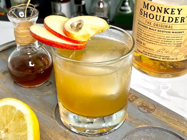 trago de whisky con jugo de manzana y rodajas de fruta